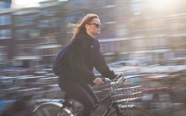 Žena v meste idúca na bicykli